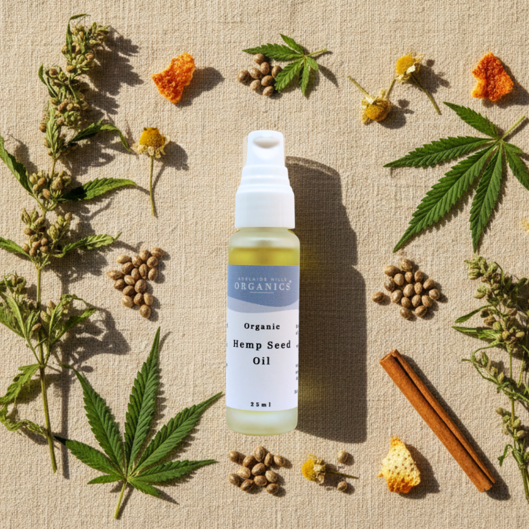 Organic Hemp Seed Oil bottle on linen surrounded by hemp leaves, seeds and calendula flowers