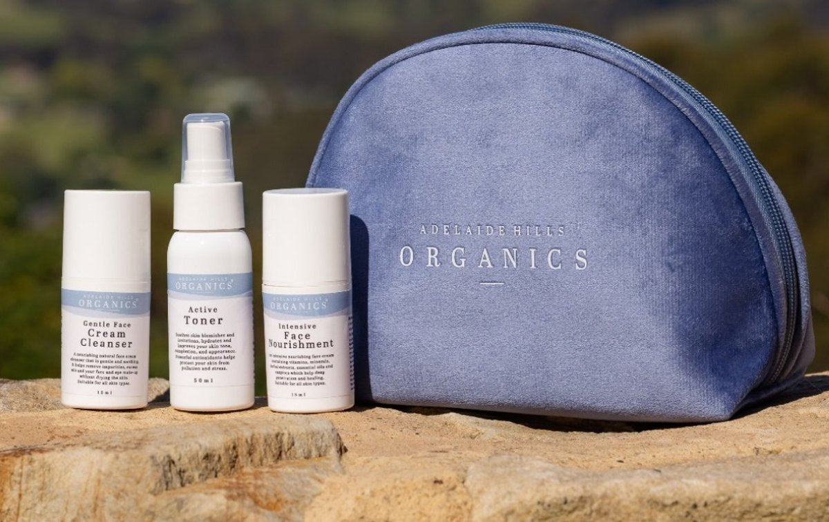 Adelaide Hills Organics travel bag with skincare minis on a stone wall
